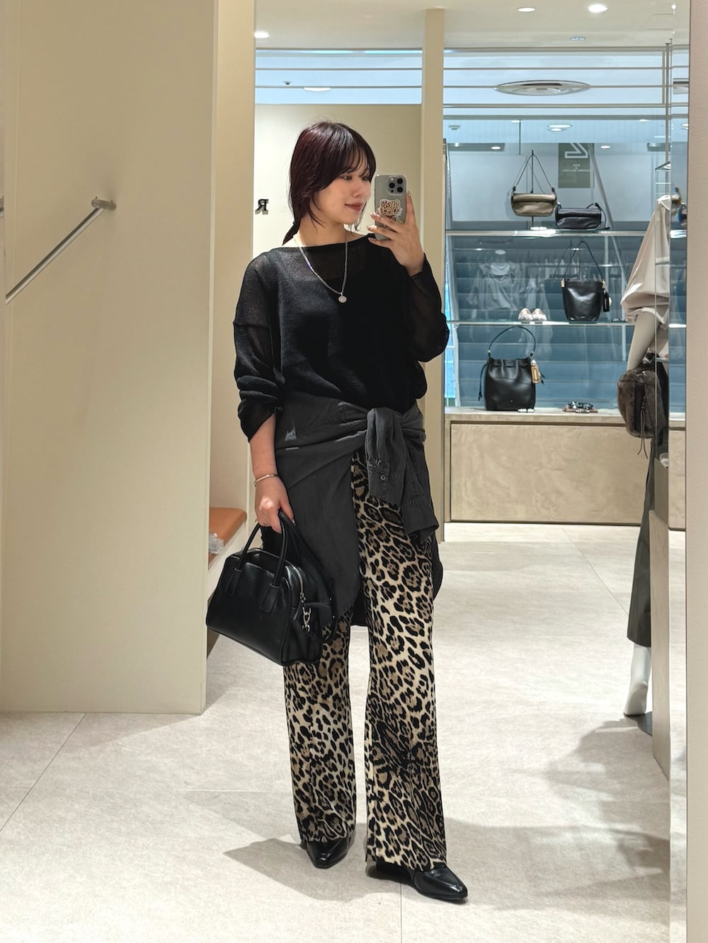 ブラック系のニット/セーター、ベージュ系のその他パンツ、ブラック系のシャツ/ブラウスを着用したレディースの秋コーディネートの2枚目の写真