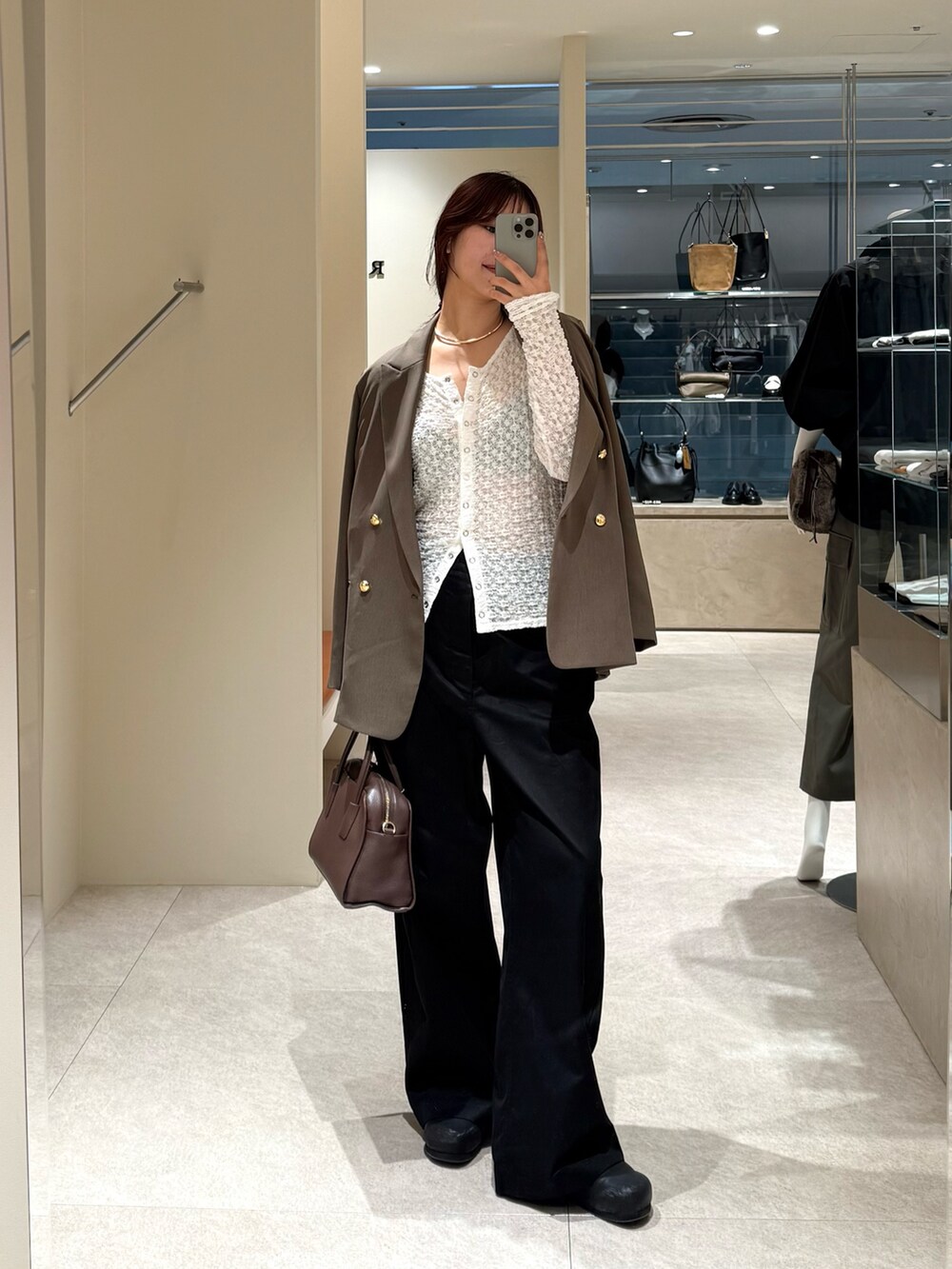 ブラック系のチノパンツ、ブラウン系のテーラードジャケット、ブラウン系のボストンバッグを着用したレディースの秋コーディネートの4枚目の写真