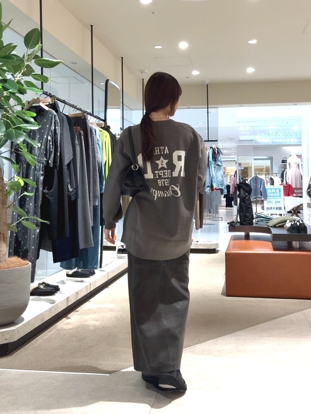 グレー系のニット/セーター、グレー系のスカートを着用したレディースの秋コーディネートの6枚目の写真