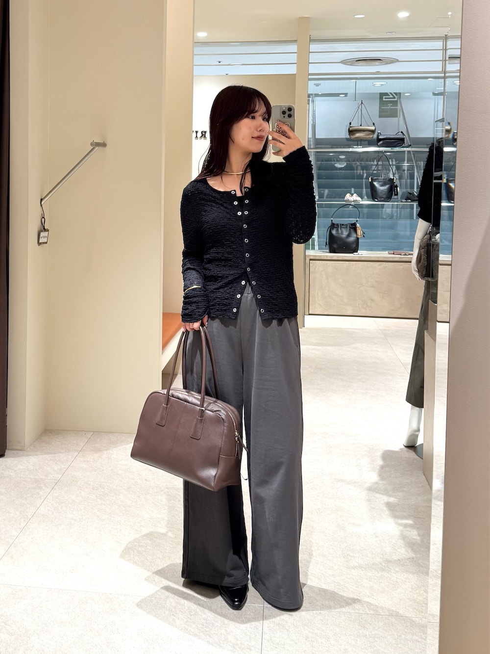 グレー系のその他パンツ、ブラック系のTシャツ/カットソー、ブラウン系のボストンバッグを着用したレディースの秋コーディネートの2枚目の写真