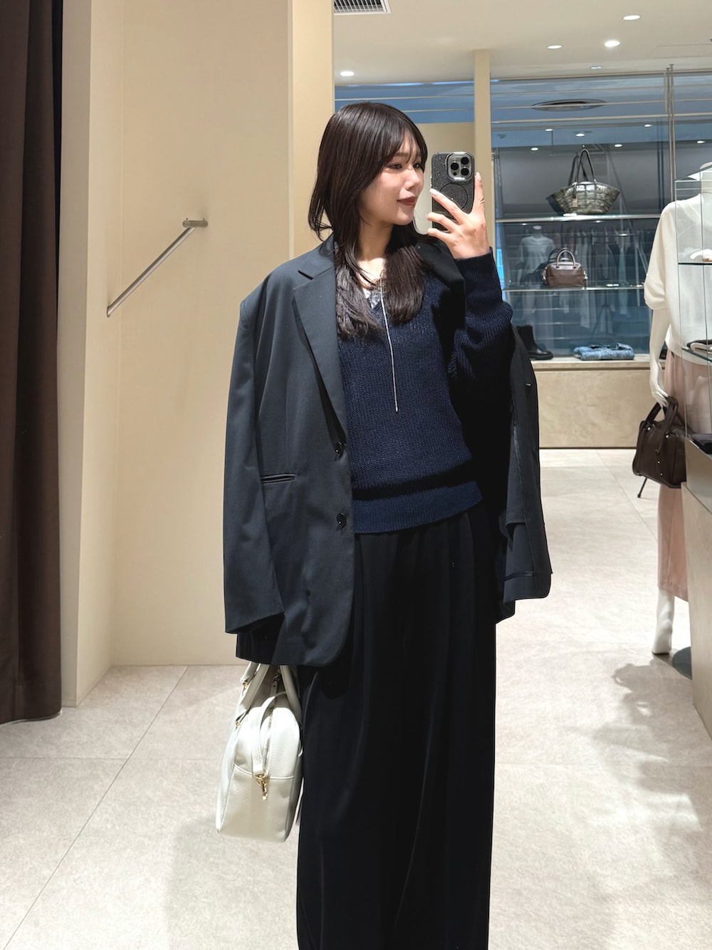 ブルー系のニット/セーター、ブラック系のテーラードジャケット、ブラック系のその他パンツを着用したレディースの春コーディネートの2枚目の写真