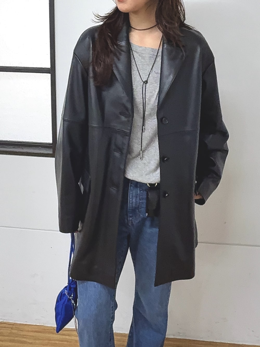 ブラック系のテーラードジャケット、ブルー系のデニムパンツ、グレー系のTシャツ/カットソーを着用したレディースの秋コーディネートの4枚目の写真