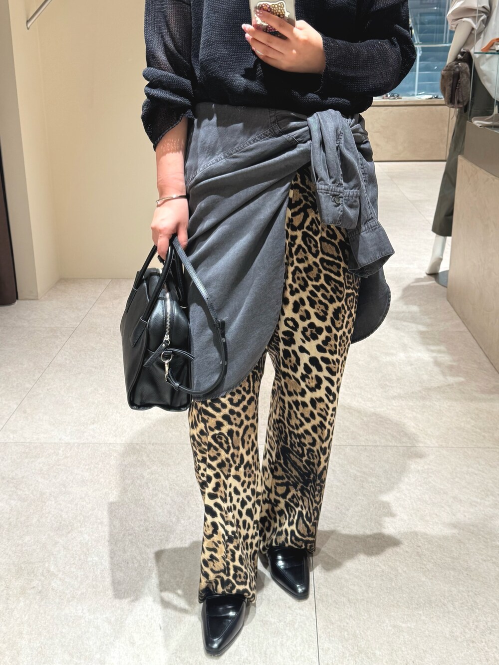 ブラック系のニット/セーター、ベージュ系のその他パンツ、ブラック系のシャツ/ブラウスを着用したレディースの秋コーディネートの4枚目の写真