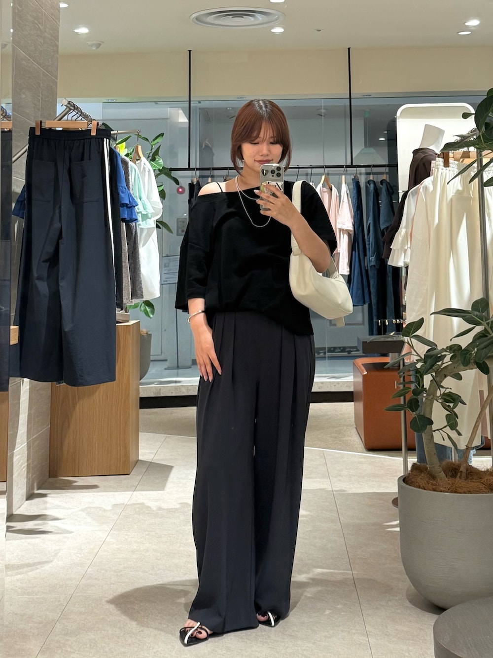 ブラック系のサンダル、ブラック系のTシャツ/カットソー、グレー系のスラックスを着用したレディースの夏コーディネートの3枚目の写真