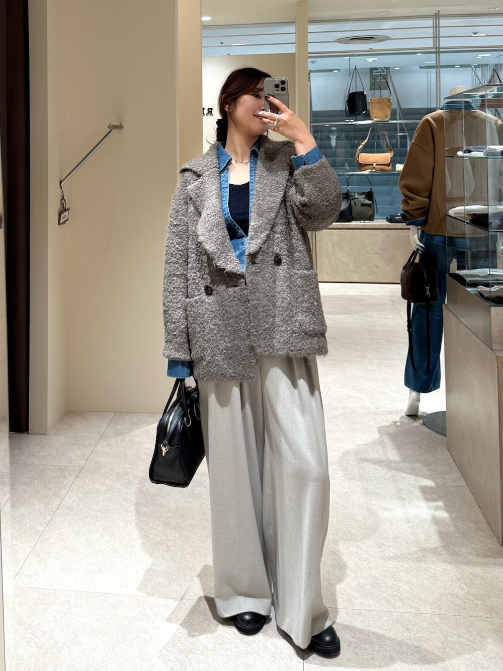 ブラウン系のその他アウター、ブルー系のシャツ/ブラウス、ブラック系のボストンバッグを着用したレディースの秋コーディネートの2枚目の写真