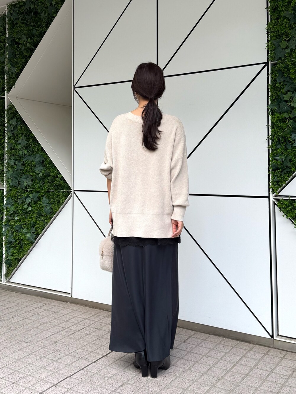 ホワイト系のニット/セーター、ブラック系のスカート、ブラック系のキャミソールを着用したレディースの秋コーディネートの4枚目の写真