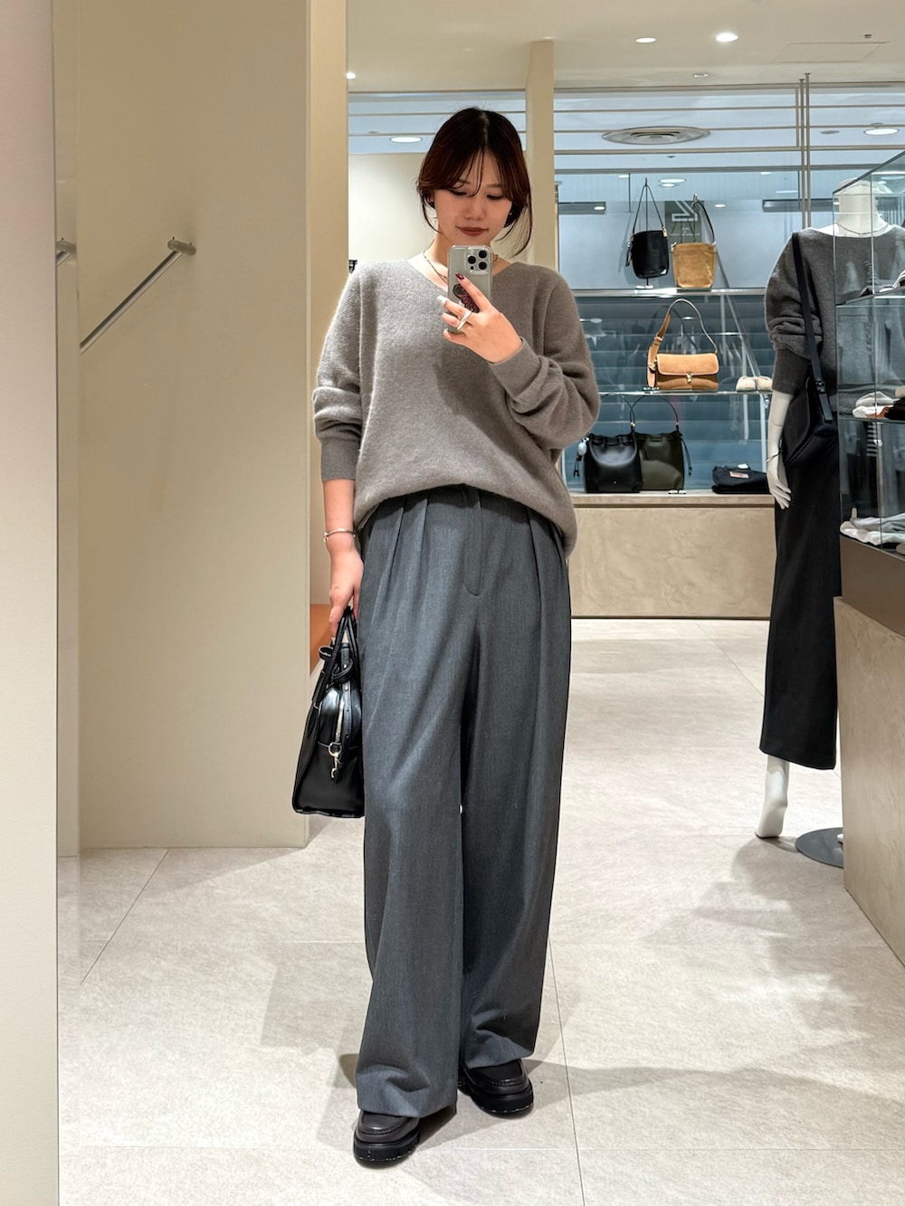 グレー系のニット/セーター、グレー系のスラックスを着用したレディースの秋コーディネートの2枚目の写真