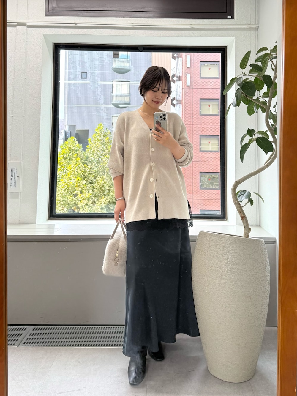 ホワイト系のニット/セーター、ブラック系のスカート、ブラック系のキャミソールを着用したレディースの秋コーディネートの6枚目の写真