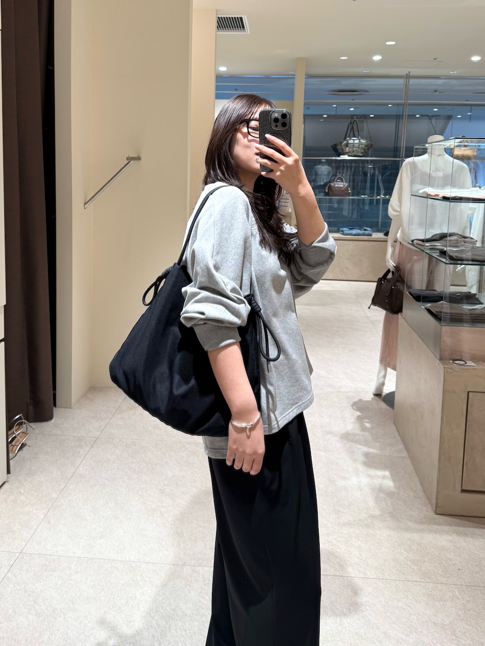 グレー系のスウェット、ブラック系のその他パンツ、ブラック系のトートバッグを着用したレディースの春コーディネートの2枚目の写真