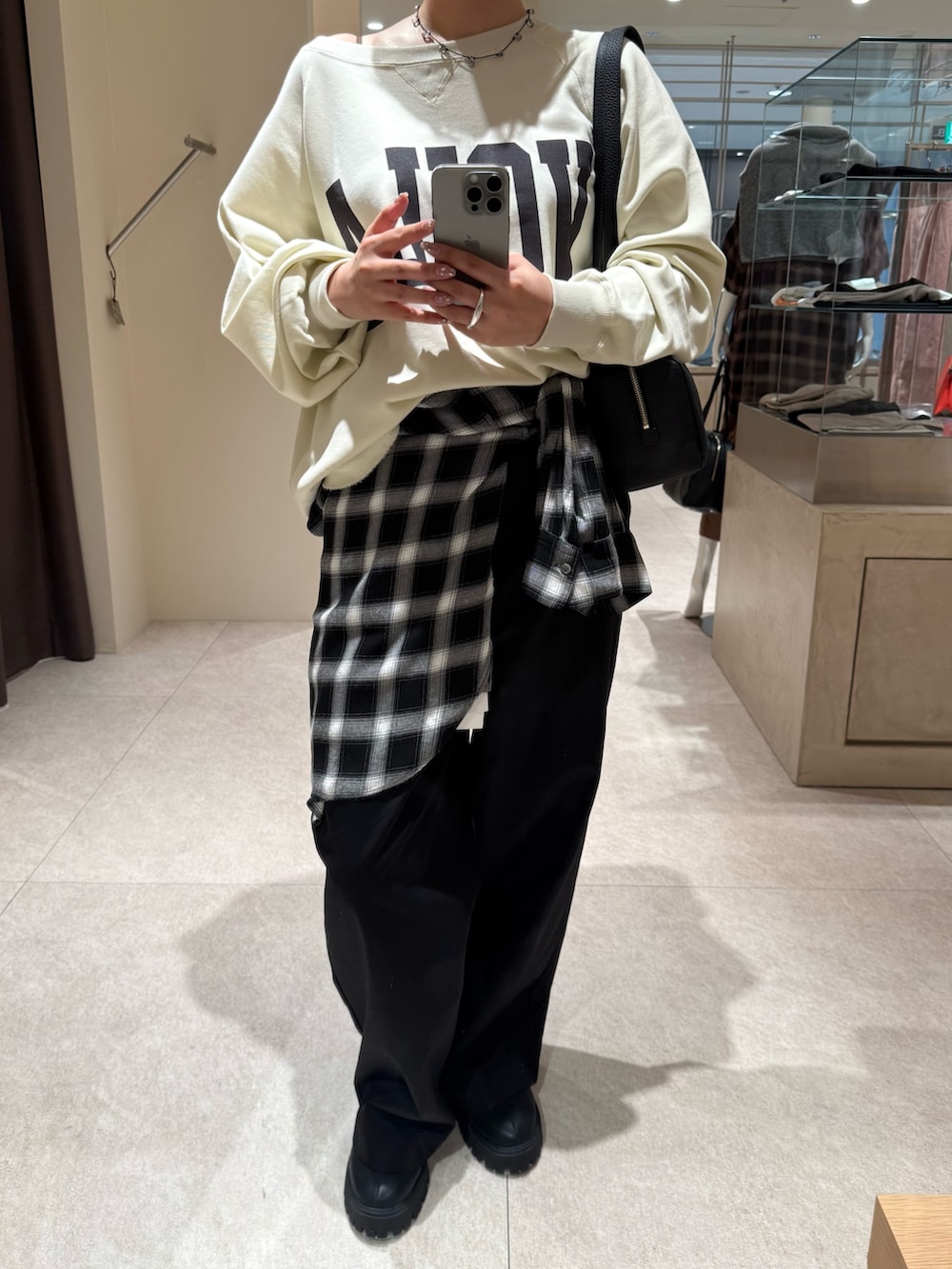 ブラック系のチノパンツ、ホワイト系のスウェット、ブラック系のシャツ/ブラウスを着用したレディースの秋コーディネートの6枚目の写真