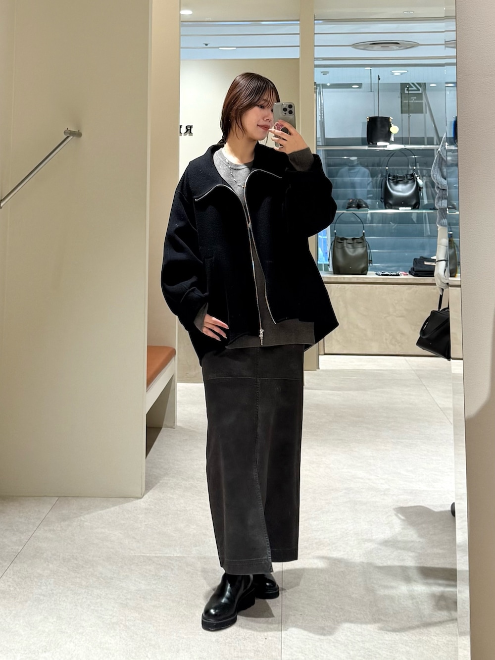 ブラック系のその他アウター、グレー系のスカート、グレー系のニット/セーターを着用したレディースの冬コーディネートの2枚目の写真