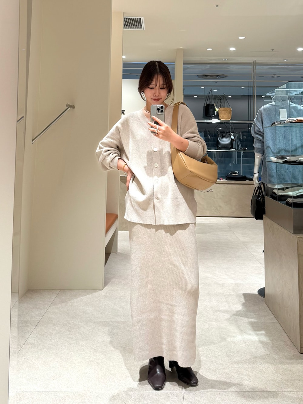 ホワイト系のニット/セーター、ホワイト系のスカートを着用したレディースの秋コーディネートの2枚目の写真