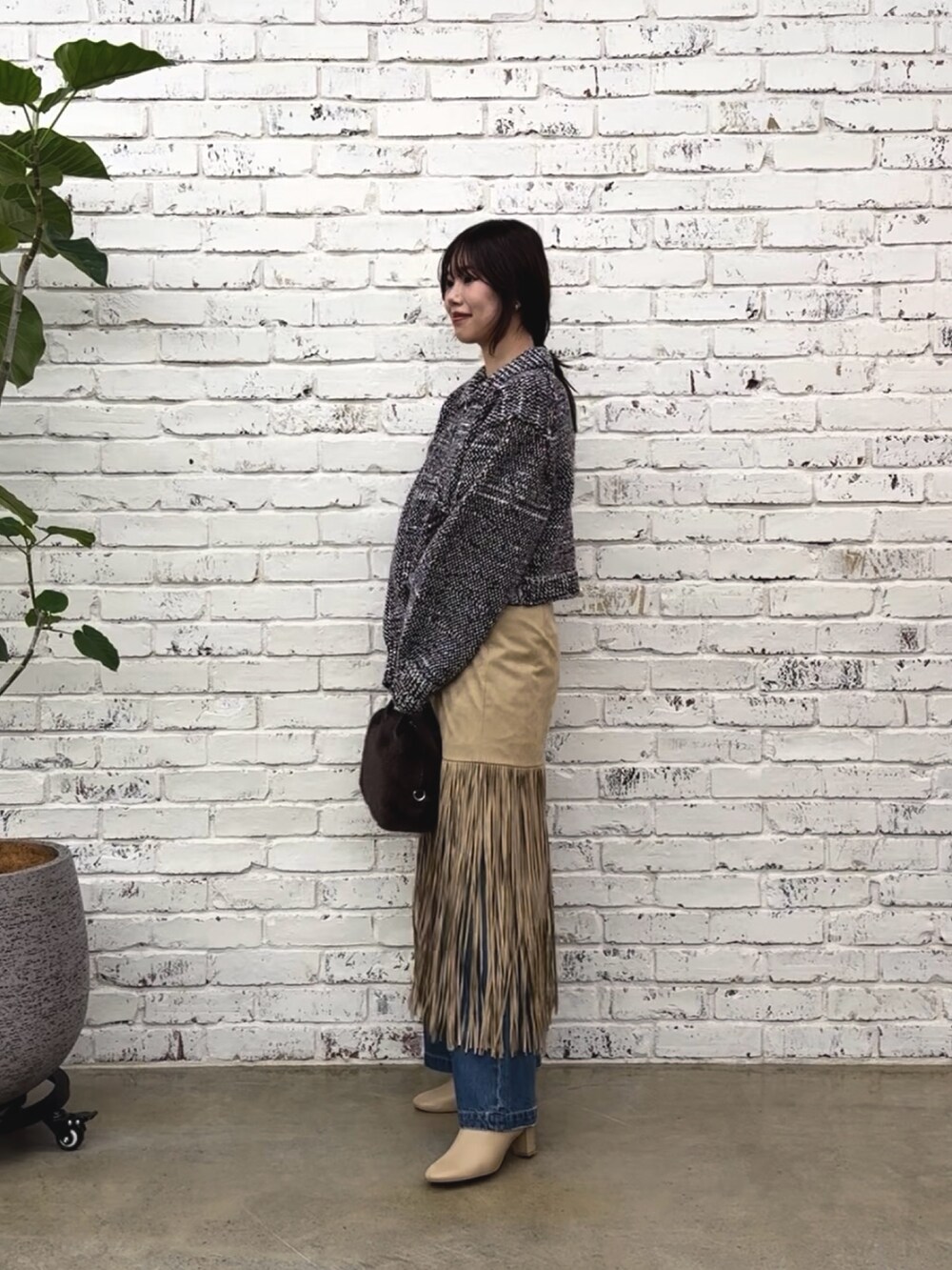 ベージュ系のスカート、ブルー系のニット/セーター、ブルー系のデニムパンツを着用したレディースの秋コーディネートの3枚目の写真