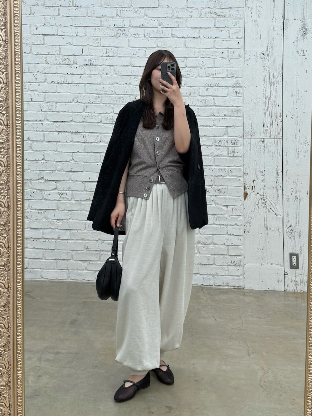 ベージュ系のその他パンツ、ブラウン系のニット/セーター、ブラック系のテーラードジャケットを着用したレディースの春コーディネートの2枚目の写真