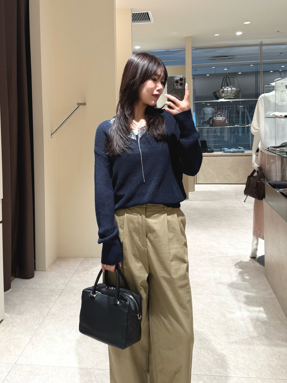 ブルー系のニット/セーター、ベージュ系のチノパンツを着用したレディースの春コーディネートの3枚目の写真