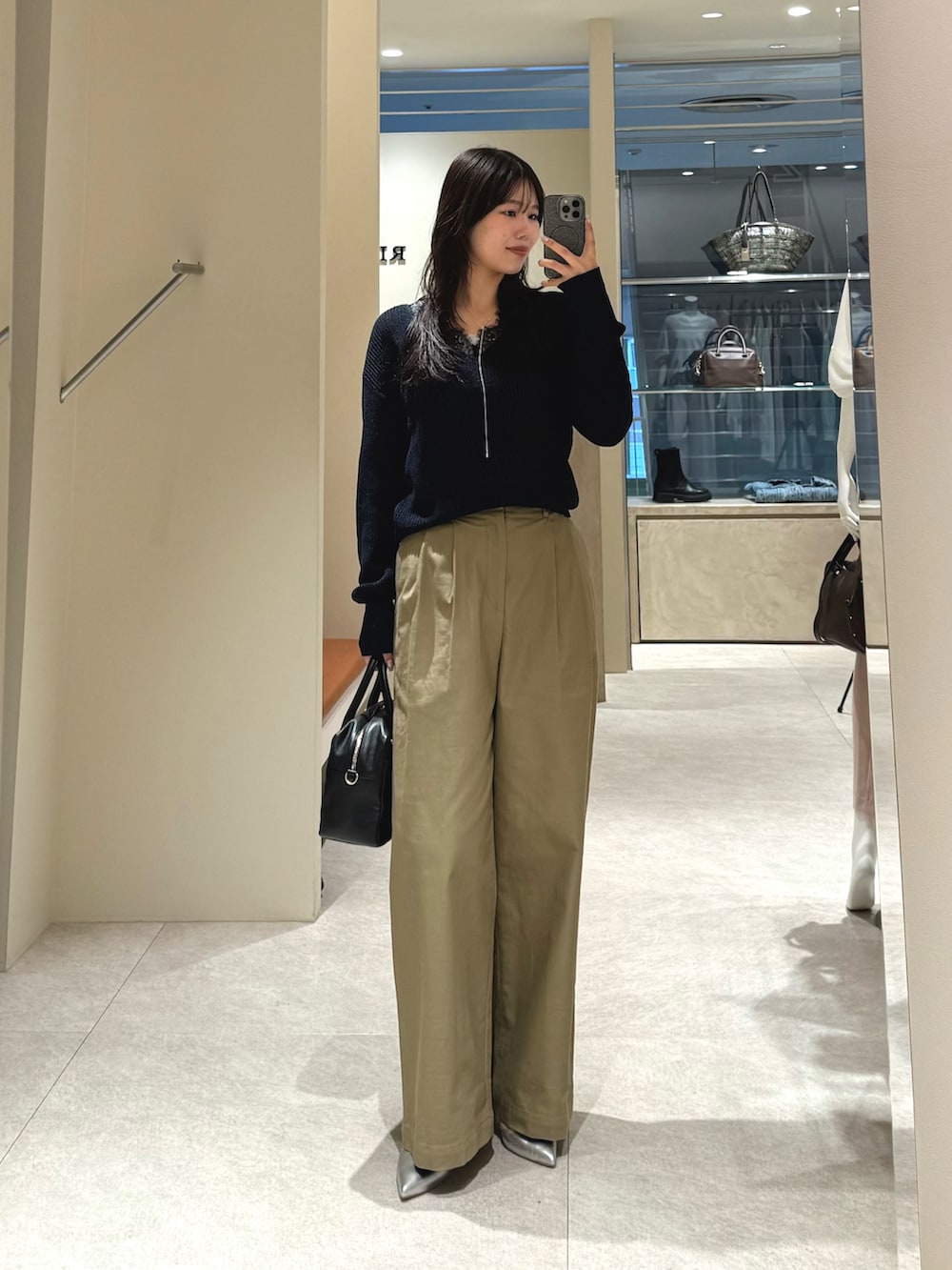 ブルー系のニット/セーター、ベージュ系のチノパンツを着用したレディースの春コーディネートの2枚目の写真