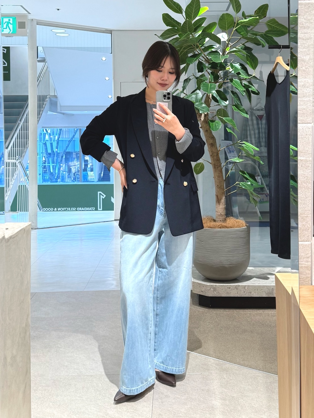 ブルー系のテーラードジャケット、ブルー系のデニムパンツ、グレー系のカーディガン/ボレロを着用したレディースの冬コーディネートの3枚目の写真