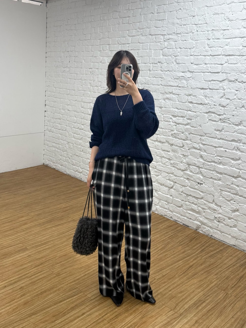 ブルー系のニット/セーター、グレー系のハンドバッグを着用したレディースの夏コーディネートの3枚目の写真