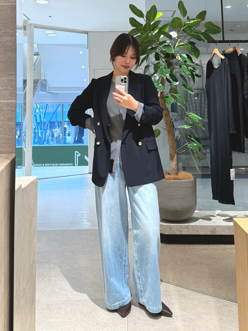 ブルー系のテーラードジャケット、ブルー系のデニムパンツ、グレー系のカーディガン/ボレロを着用したレディースの冬コーディネートの2枚目の写真
