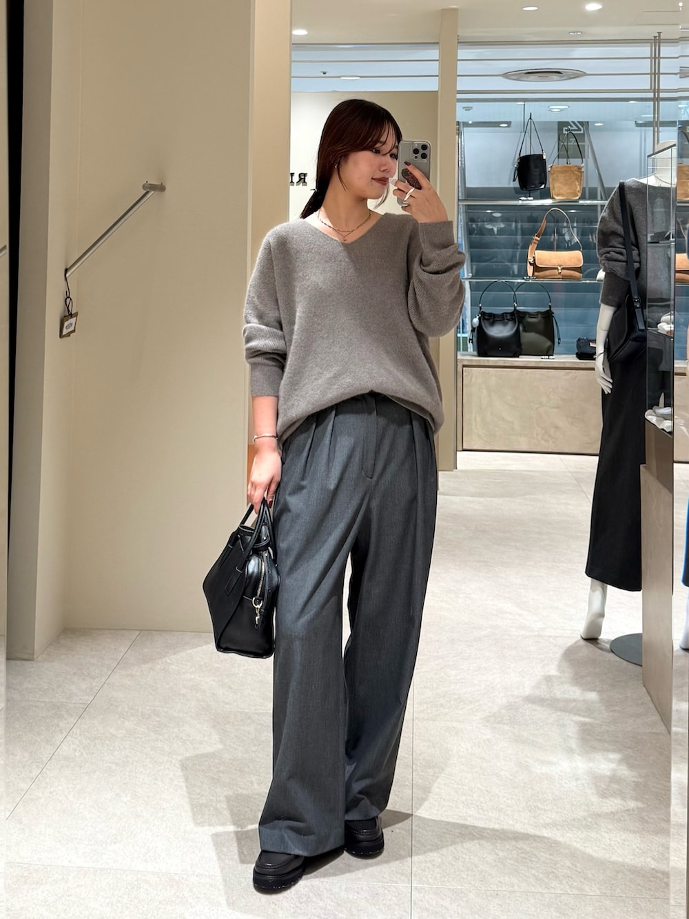 グレー系のニット/セーター、グレー系のスラックスを着用したレディースの秋コーディネートの3枚目の写真
