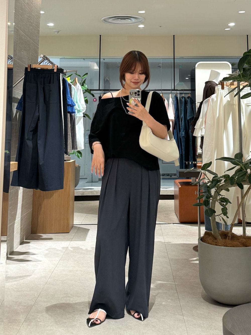 ブラック系のサンダル、ブラック系のTシャツ/カットソー、グレー系のスラックスを着用したレディースの夏コーディネートの2枚目の写真