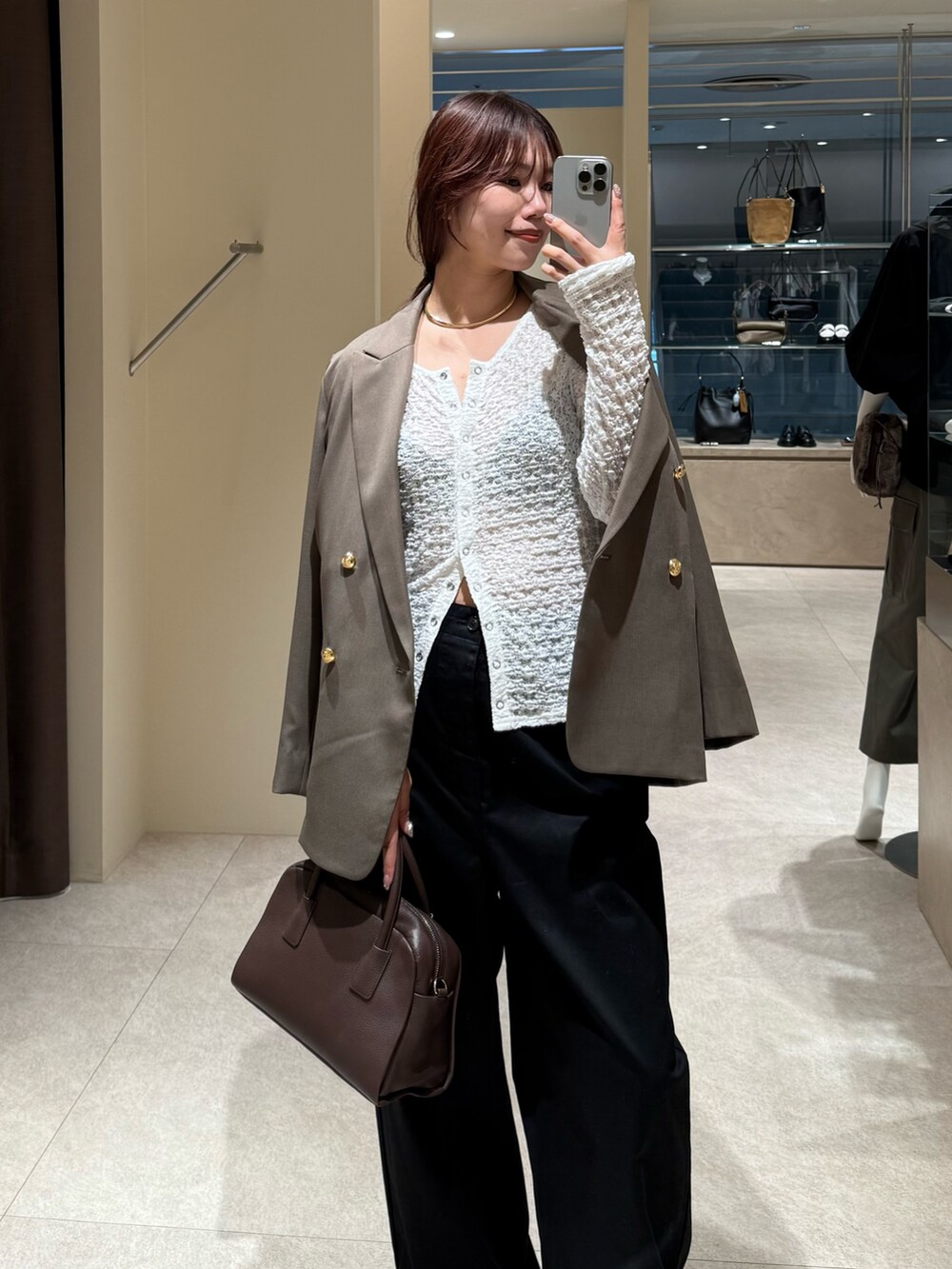 ブラック系のチノパンツ、ブラウン系のテーラードジャケット、ブラウン系のボストンバッグを着用したレディースの秋コーディネートの6枚目の写真