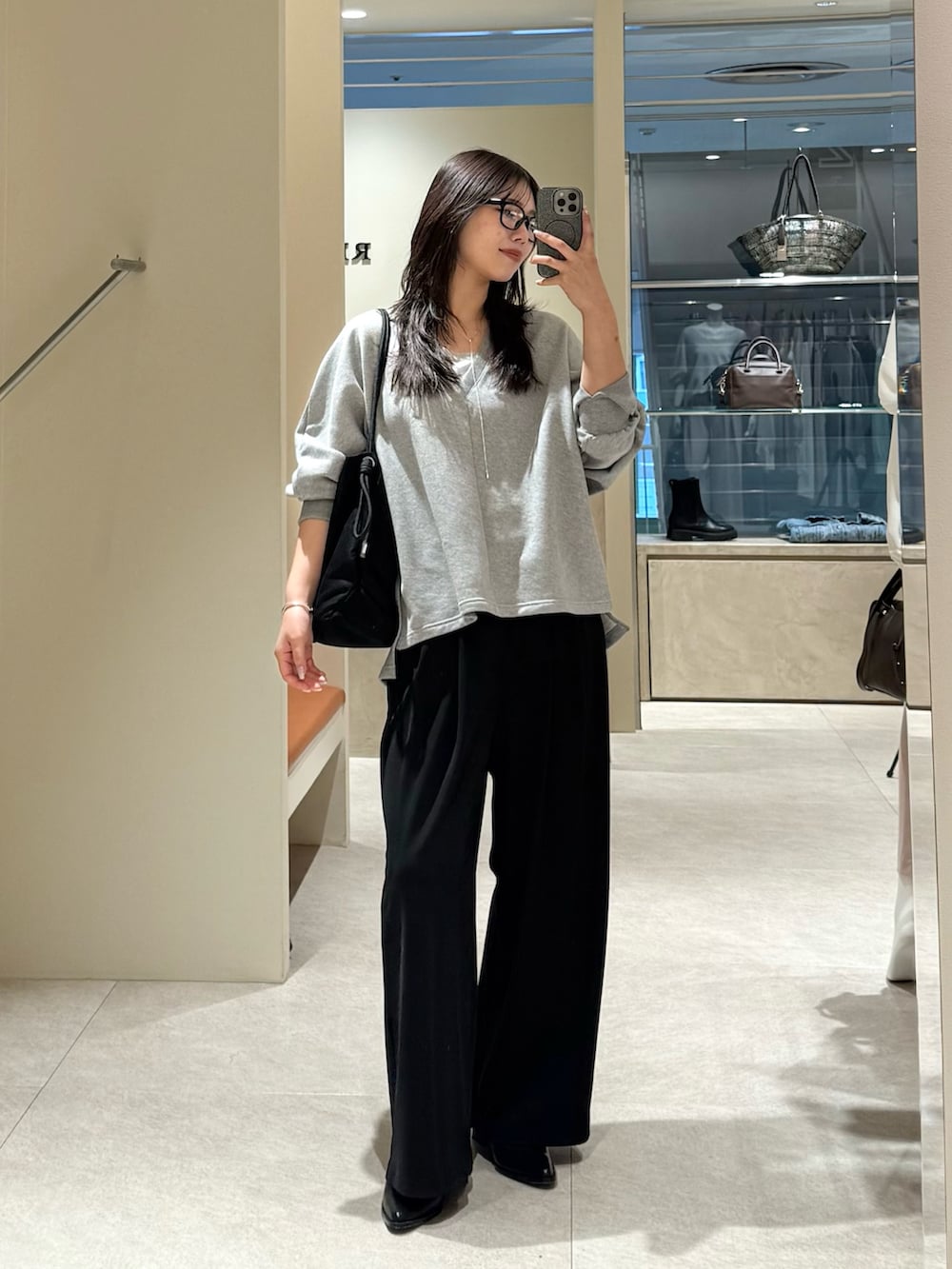 グレー系のスウェット、ブラック系のその他パンツ、ブラック系のトートバッグを着用したレディースの春コーディネートの4枚目の写真