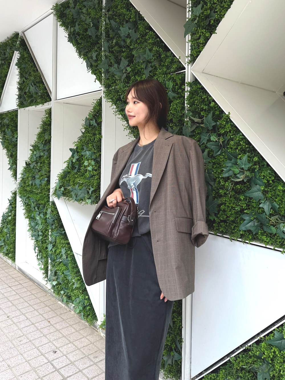 ブラウン系のテーラードジャケット、グレー系のTシャツ/カットソー、ブラック系のスカートを着用したレディースの夏コーディネートの2枚目の写真