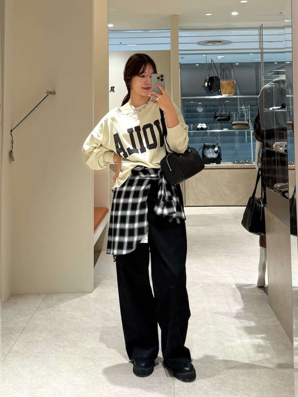 ブラック系のチノパンツ、ホワイト系のスウェット、ブラック系のシャツ/ブラウスを着用したレディースの秋コーディネートの3枚目の写真