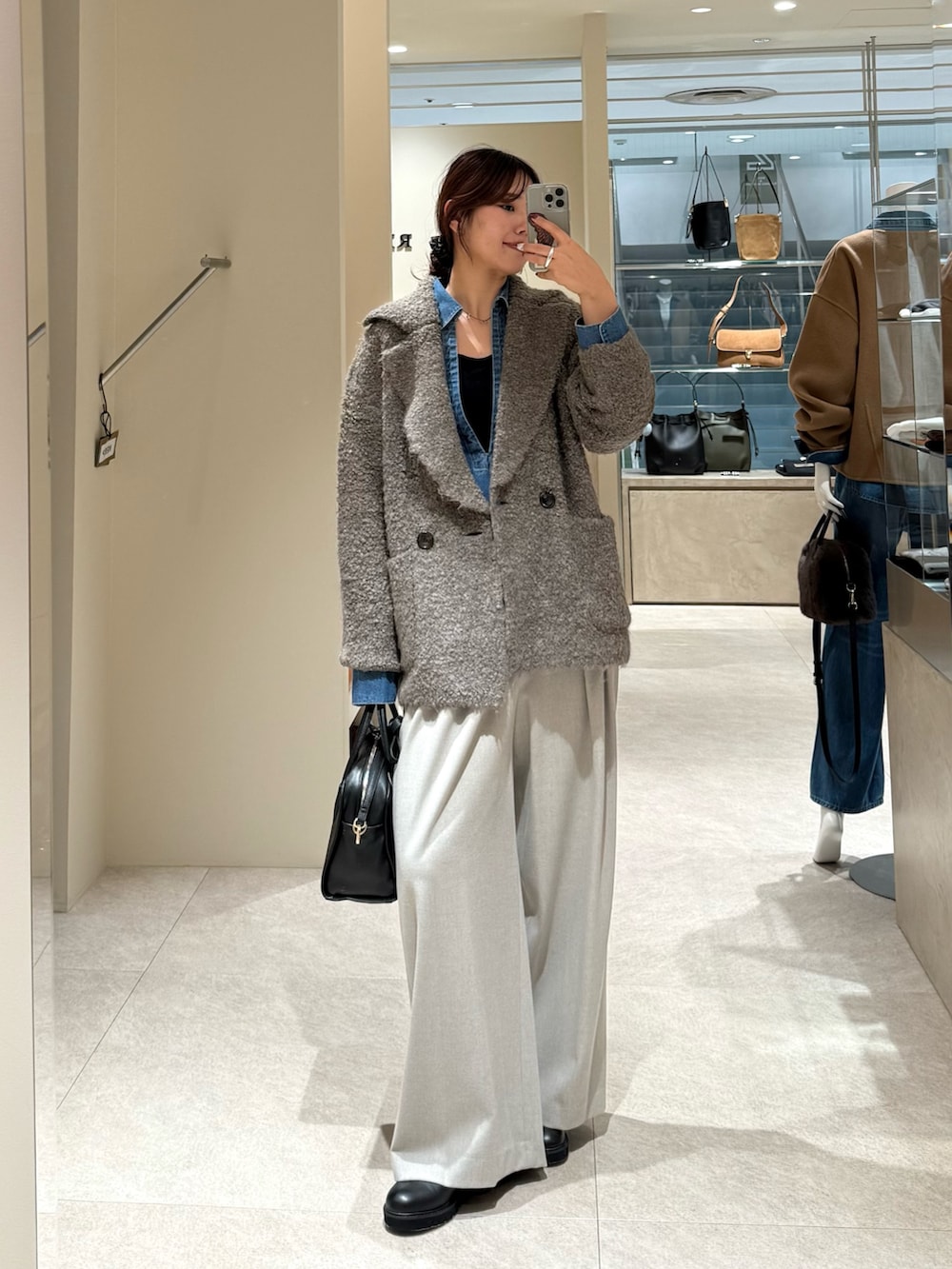 ブラウン系のその他アウター、ブルー系のシャツ/ブラウス、ブラック系のボストンバッグを着用したレディースの秋コーディネートの3枚目の写真