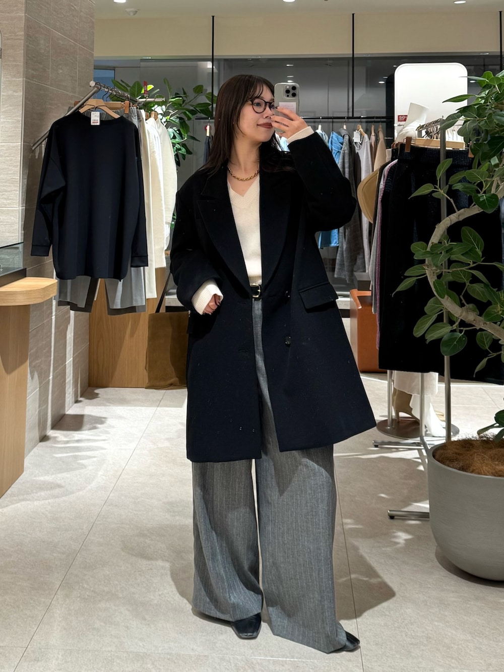 ブラック系のその他アウター、グレー系のスラックスを着用したレディースの冬コーディネートの2枚目の写真