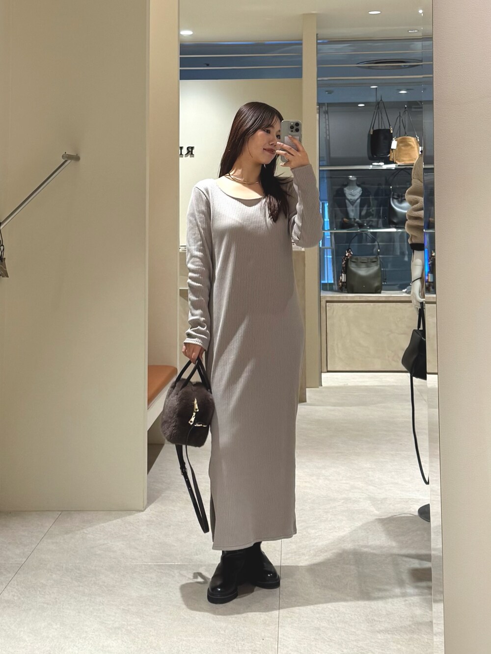 ベージュ系のワンピース、ブラウン系のボストンバッグを着用したレディースの冬コーディネートの3枚目の写真