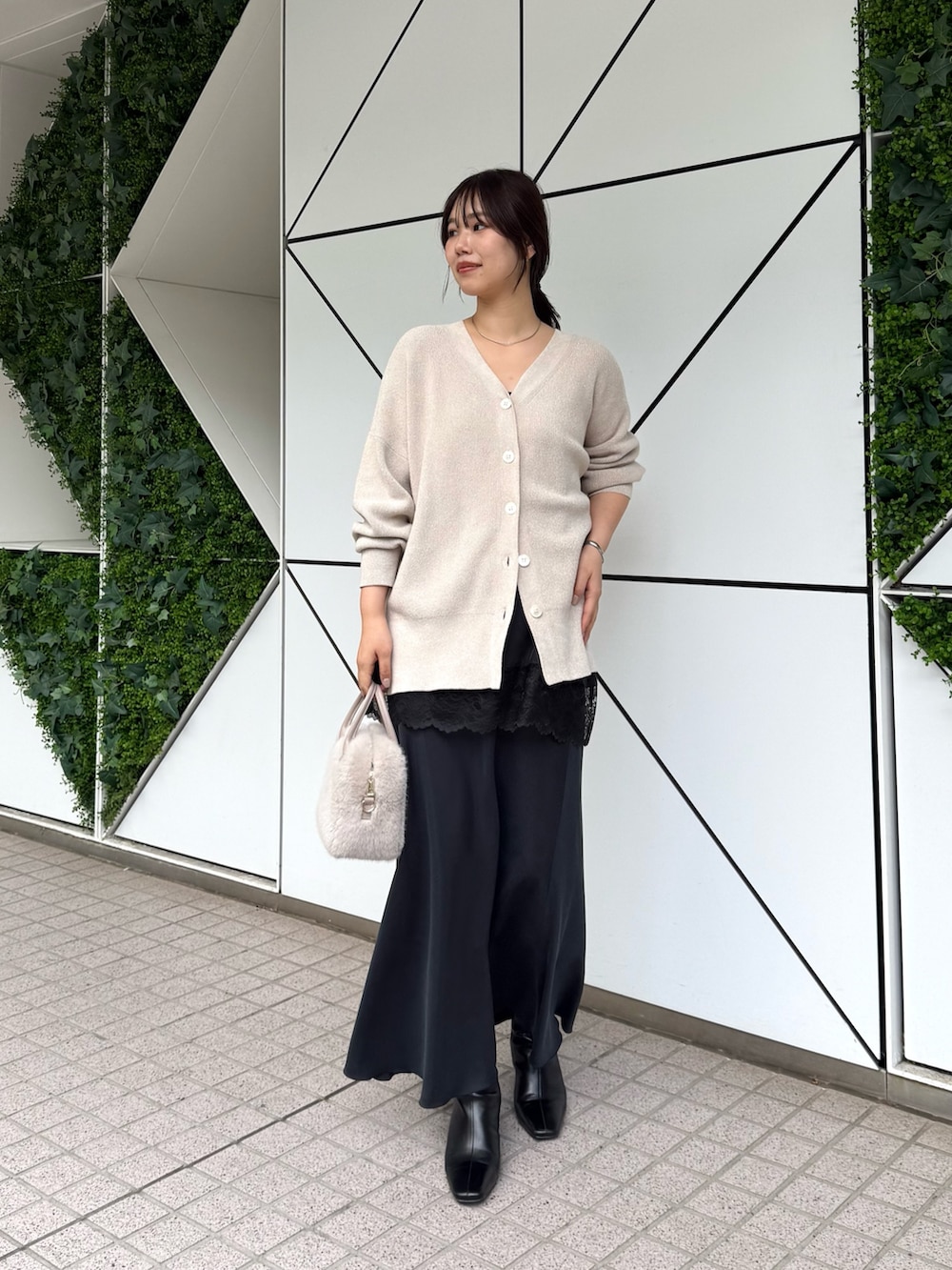 ホワイト系のニット/セーター、ブラック系のスカート、ブラック系のキャミソールを着用したレディースの秋コーディネートの3枚目の写真