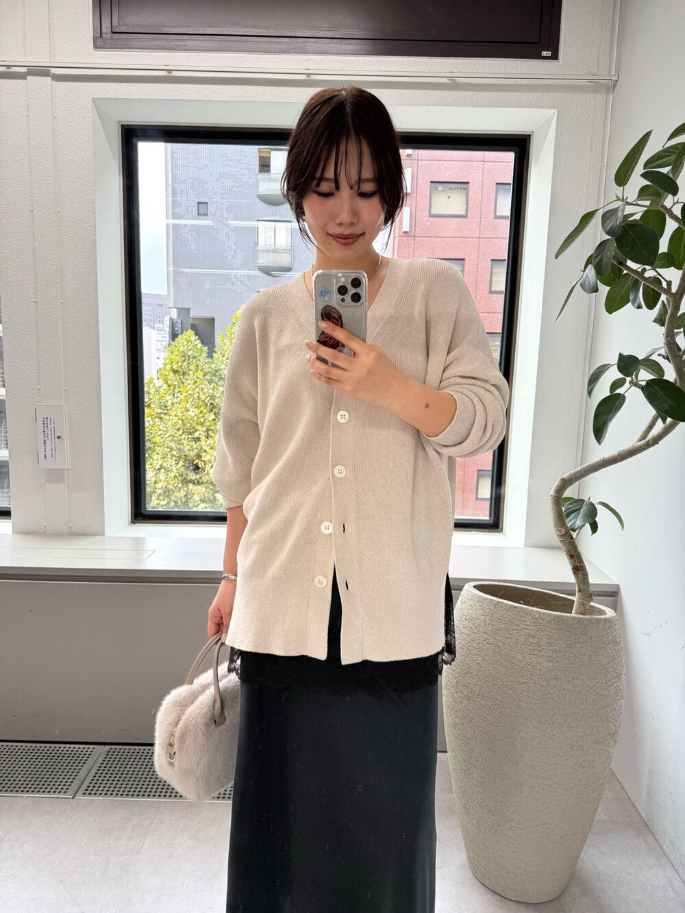 ホワイト系のニット/セーター、ブラック系のスカート、ブラック系のキャミソールを着用したレディースの秋コーディネートの7枚目の写真