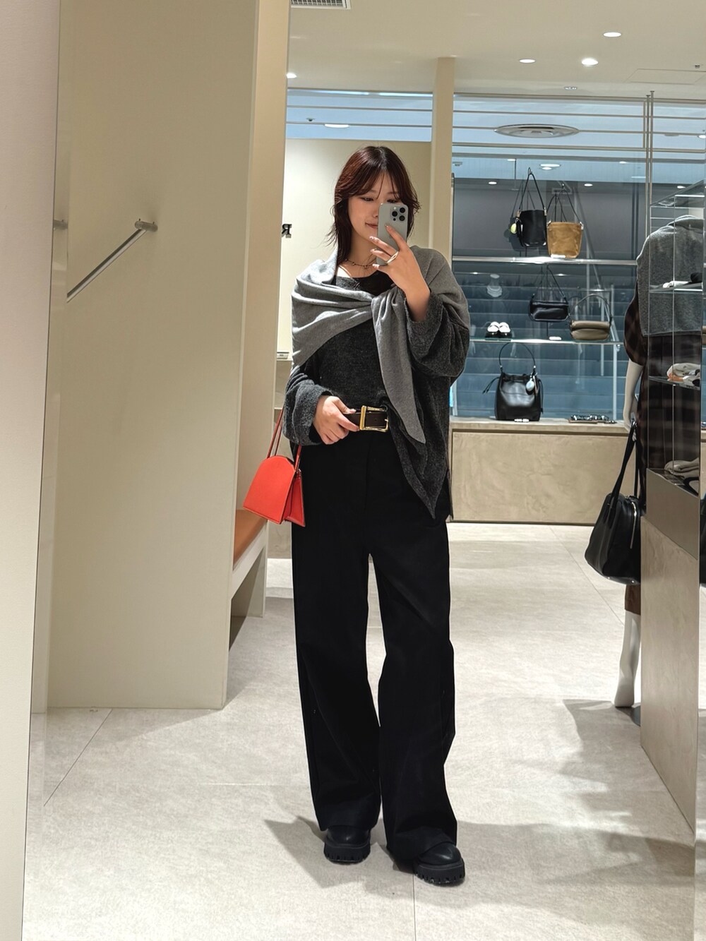 ブラック系のチノパンツ、グレー系のニット/セーター、グレー系のストール/ショールを着用したレディースの秋コーディネートの3枚目の写真