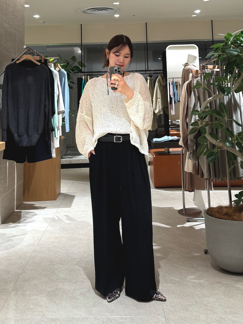 ホワイト系のニット/セーター、ブラック系のスラックス、ブラック系のベルトを着用したレディースの春コーディネートの3枚目の写真