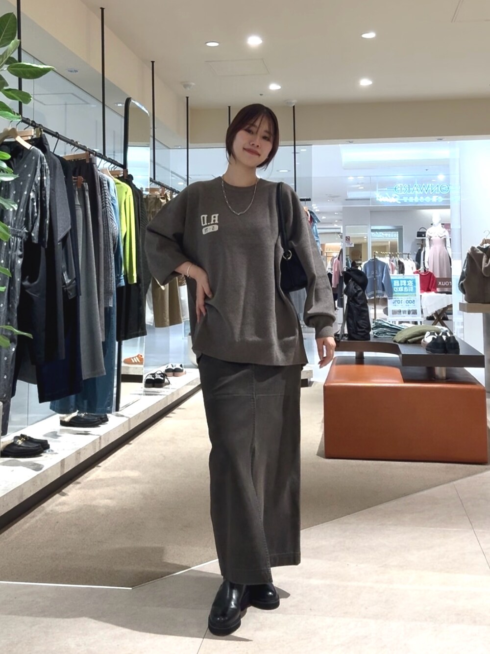 グレー系のニット/セーター、グレー系のスカートを着用したレディースの秋コーディネートの5枚目の写真