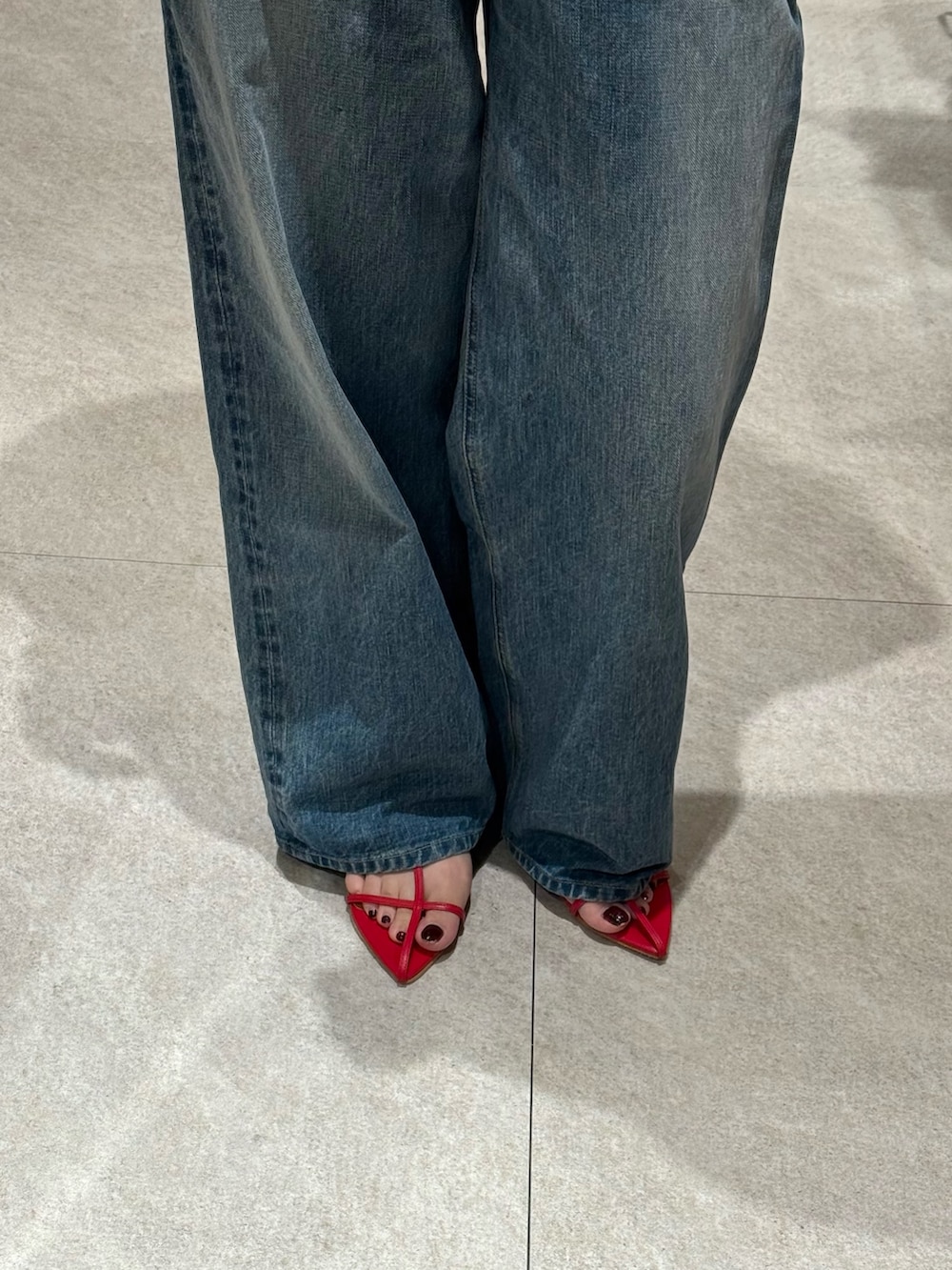 ブラック系のTシャツ/カットソー、ブルー系のデニムパンツ、レッド系のサンダルを着用したレディースの夏コーディネートの4枚目の写真