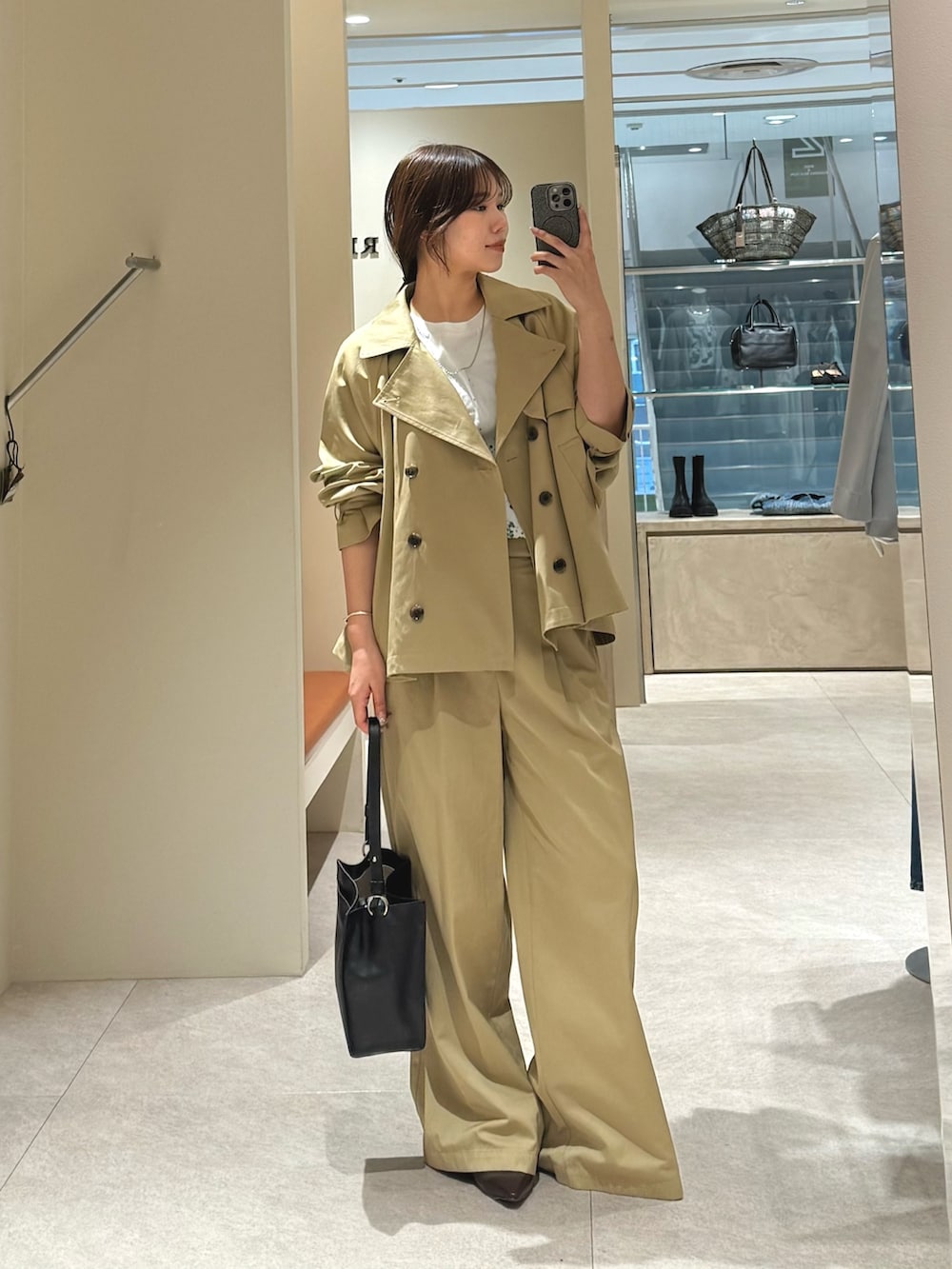 ベージュ系のトレンチコート、ベージュ系のその他パンツを着用したレディースの冬コーディネートの2枚目の写真