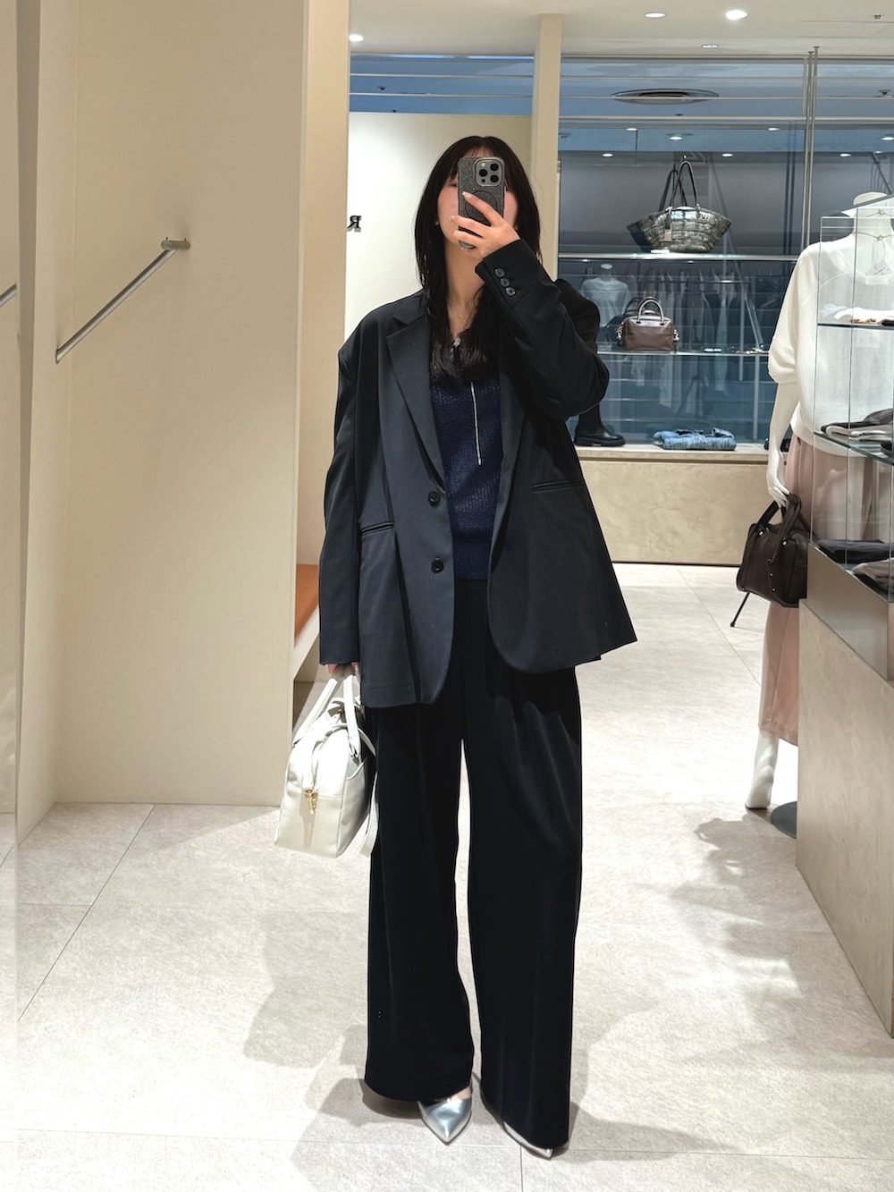 ブルー系のニット/セーター、ブラック系のテーラードジャケット、ブラック系のその他パンツを着用したレディースの春コーディネートの3枚目の写真