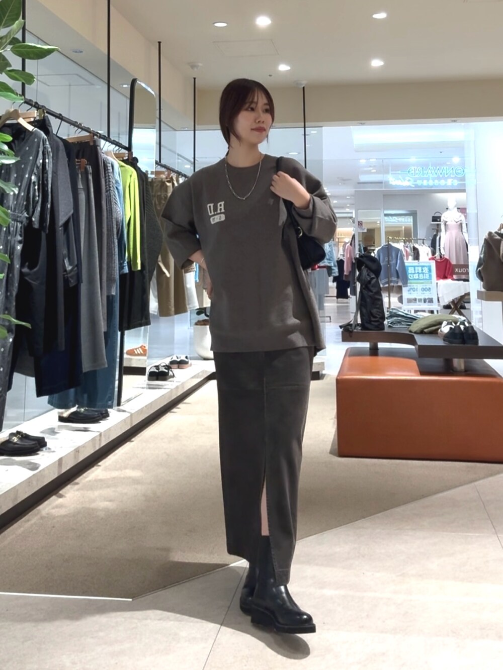 グレー系のニット/セーター、グレー系のスカートを着用したレディースの秋コーディネートの4枚目の写真