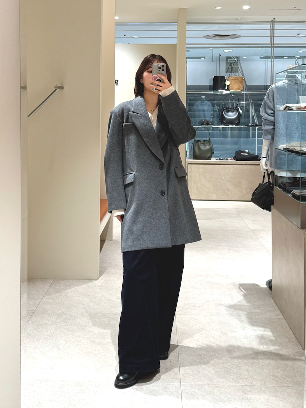 グレー系のその他アウター、ブラック系のその他パンツ、ホワイト系のニット/セーターを着用したレディースの冬コーディネートの2枚目の写真