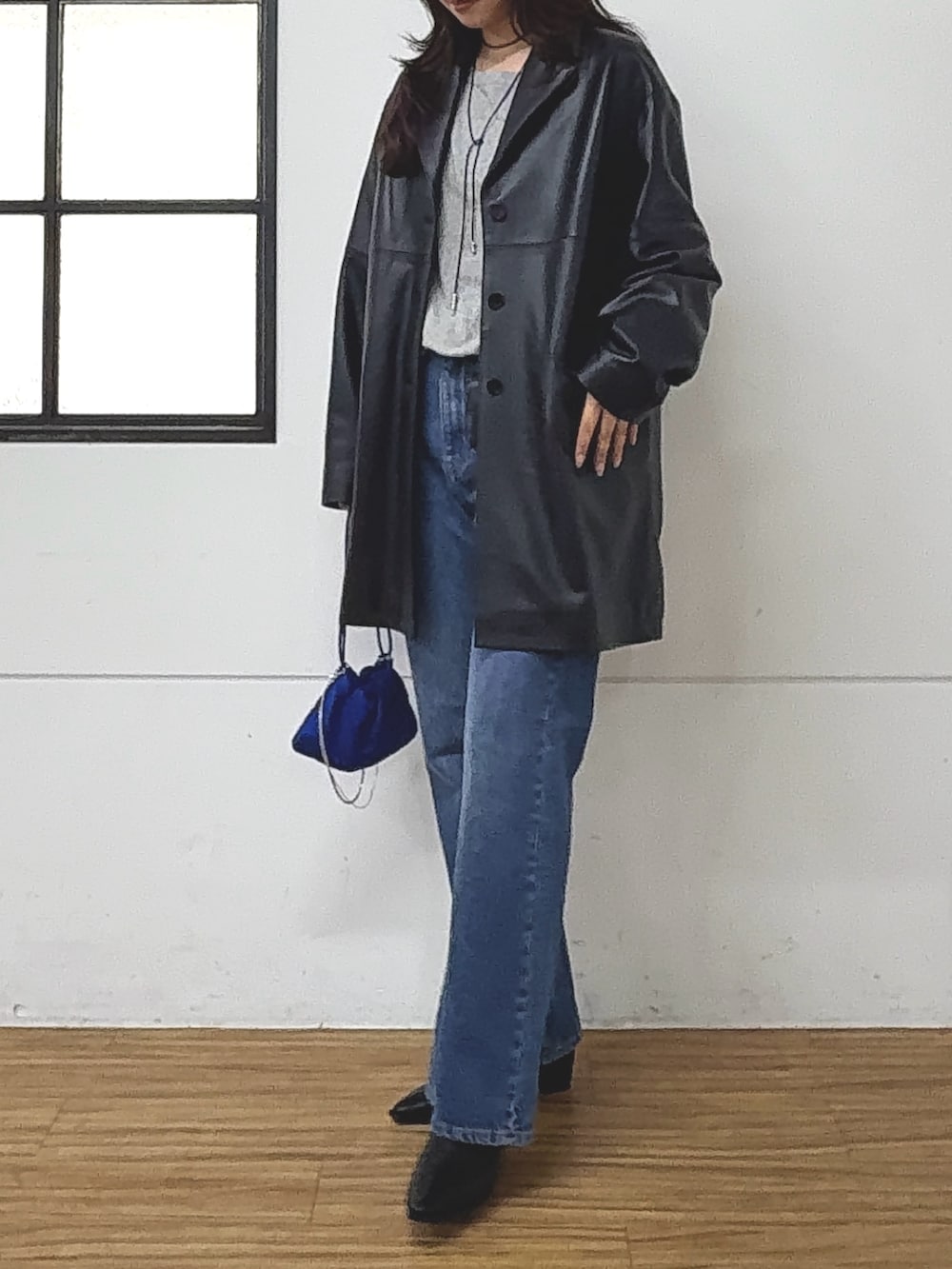 ブラック系のテーラードジャケット、ブルー系のデニムパンツ、グレー系のTシャツ/カットソーを着用したレディースの秋コーディネートの3枚目の写真