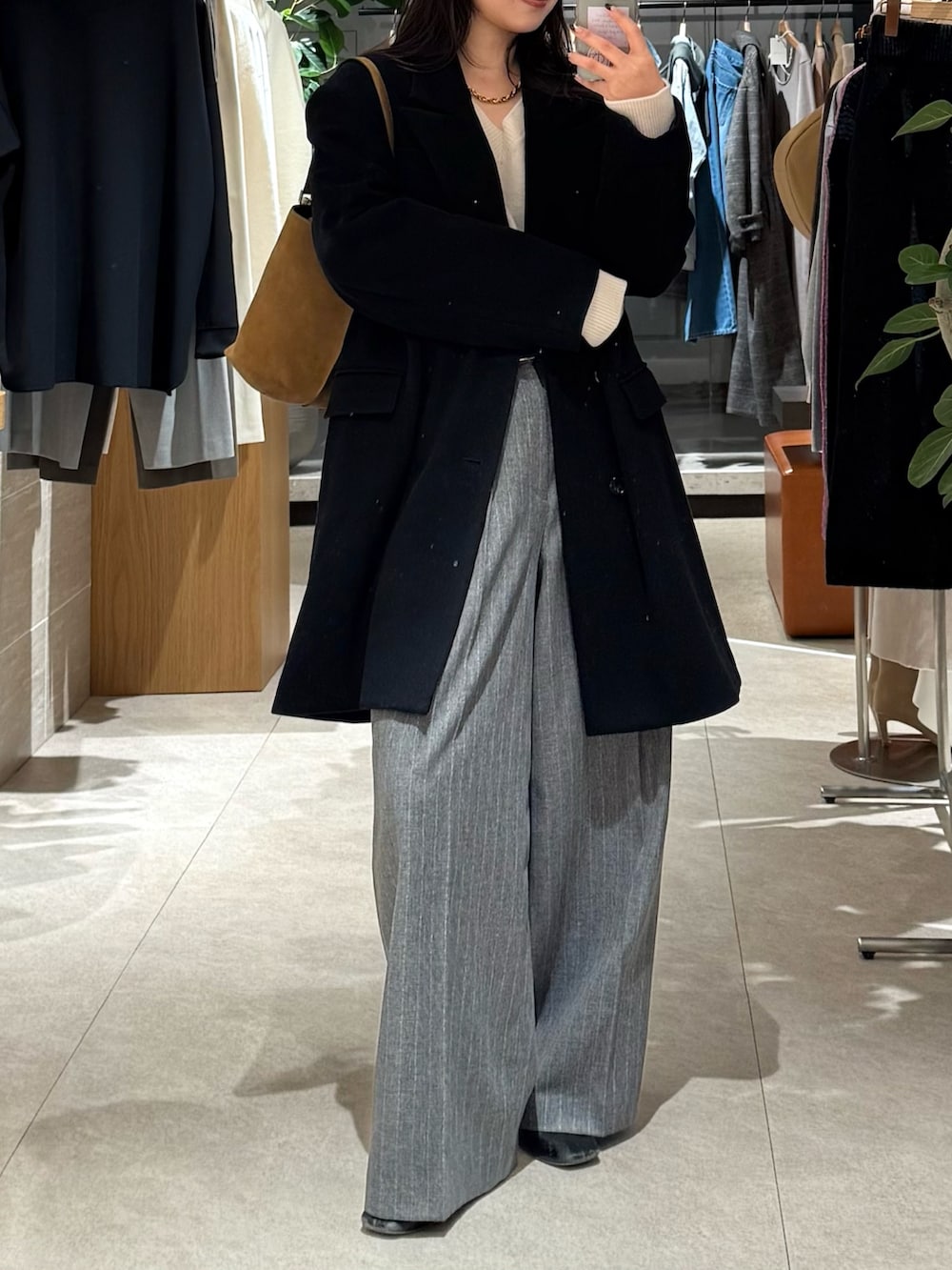 ブラック系のその他アウター、グレー系のスラックスを着用したレディースの冬コーディネートの4枚目の写真