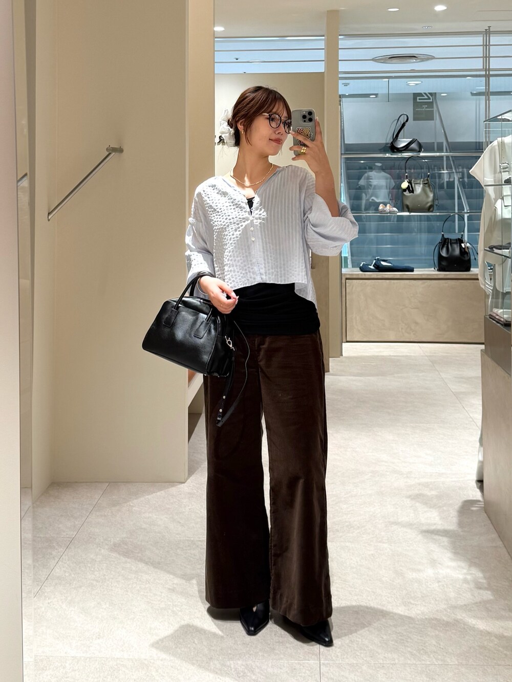 ブルー系のシャツ/ブラウス、ブラック系のキャミソール、ブラック系のボストンバッグを着用したレディースの夏コーディネートの3枚目の写真