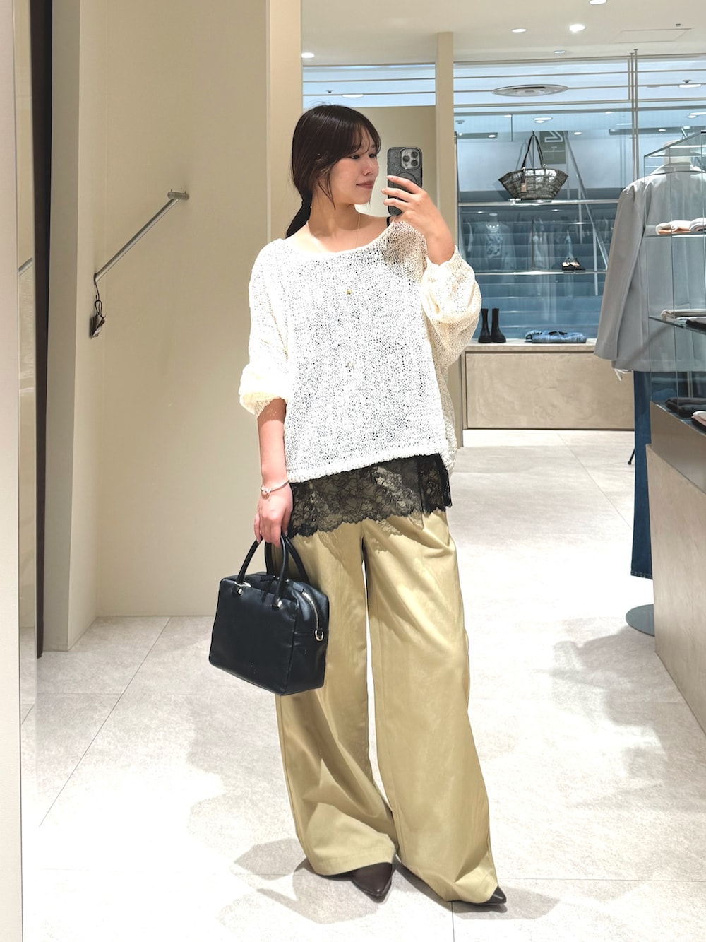 ホワイト系のニット/セーター、ベージュ系のその他パンツ、ブラック系のキャミソールを着用したレディースの春コーディネートの2枚目の写真