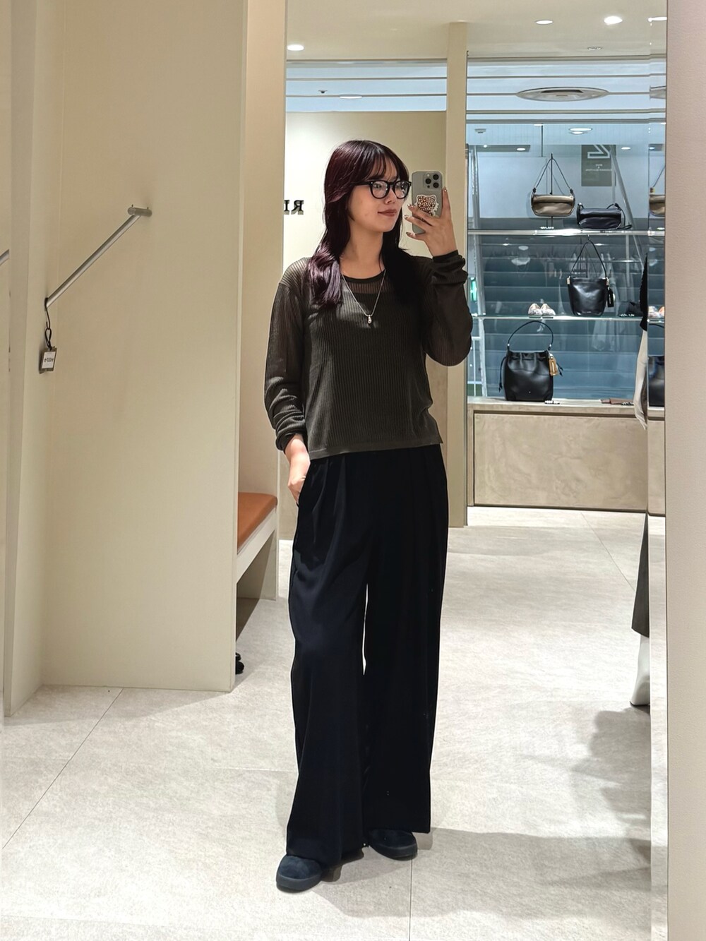 グリーン系のニット/セーター、ブラック系のスラックス、ブラウン系のボストンバッグを着用したレディースの秋コーディネートの3枚目の写真