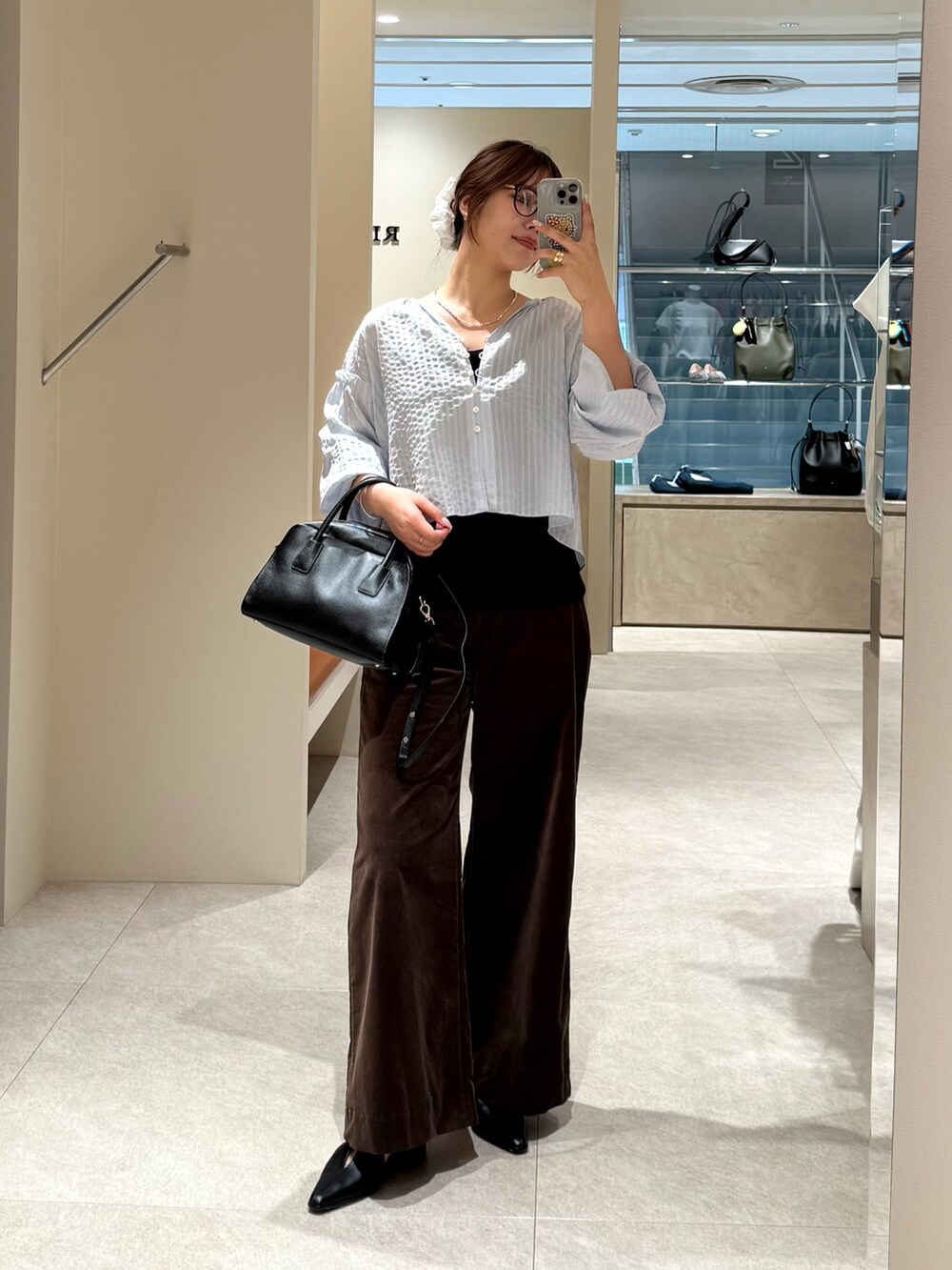 ブルー系のシャツ/ブラウス、ブラック系のキャミソール、ブラック系のボストンバッグを着用したレディースの夏コーディネートの2枚目の写真