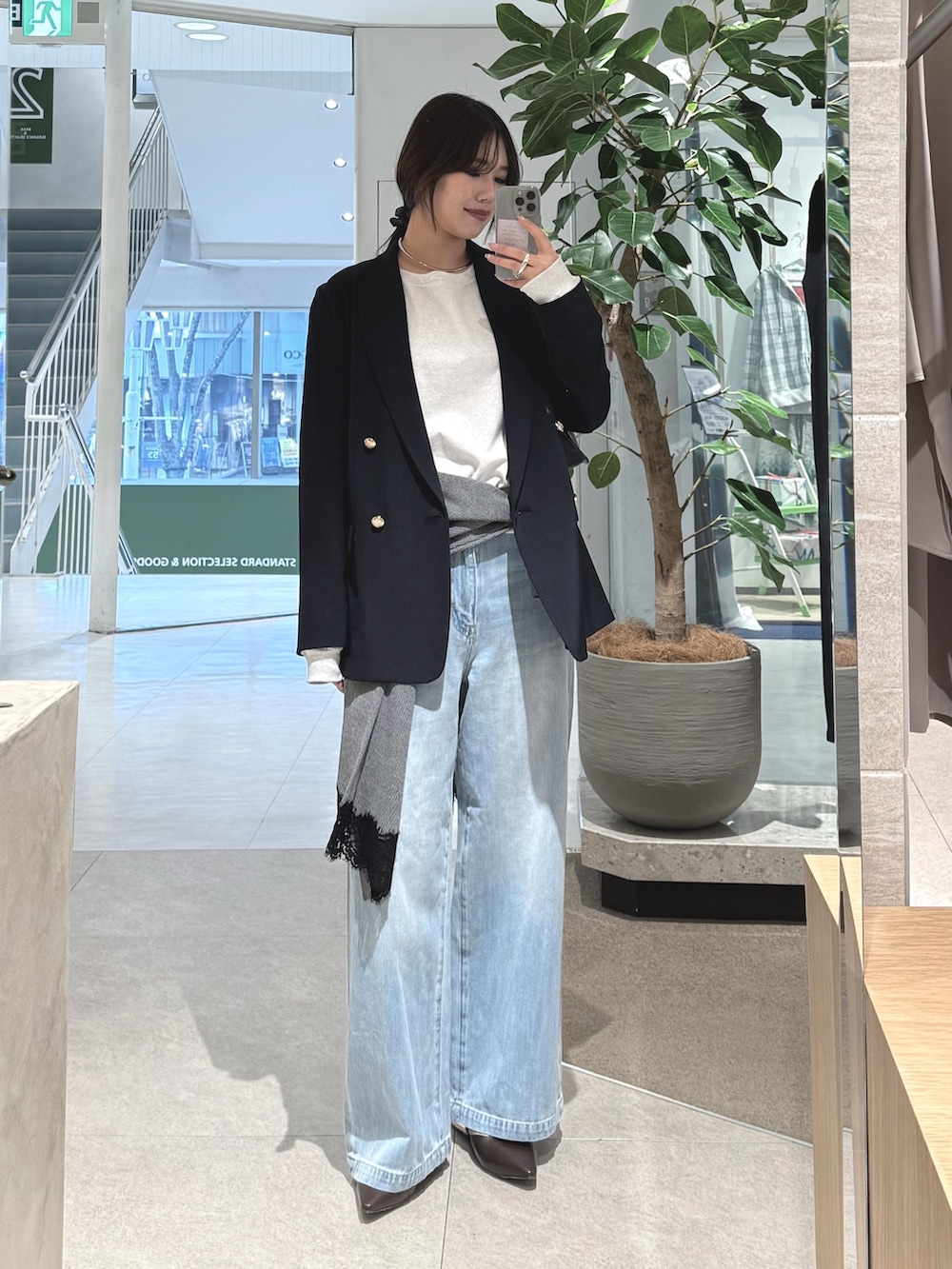 ブルー系のデニムパンツ、ブルー系のテーラードジャケット、グレー系のカーディガン/ボレロを着用したレディースの冬コーディネートの2枚目の写真