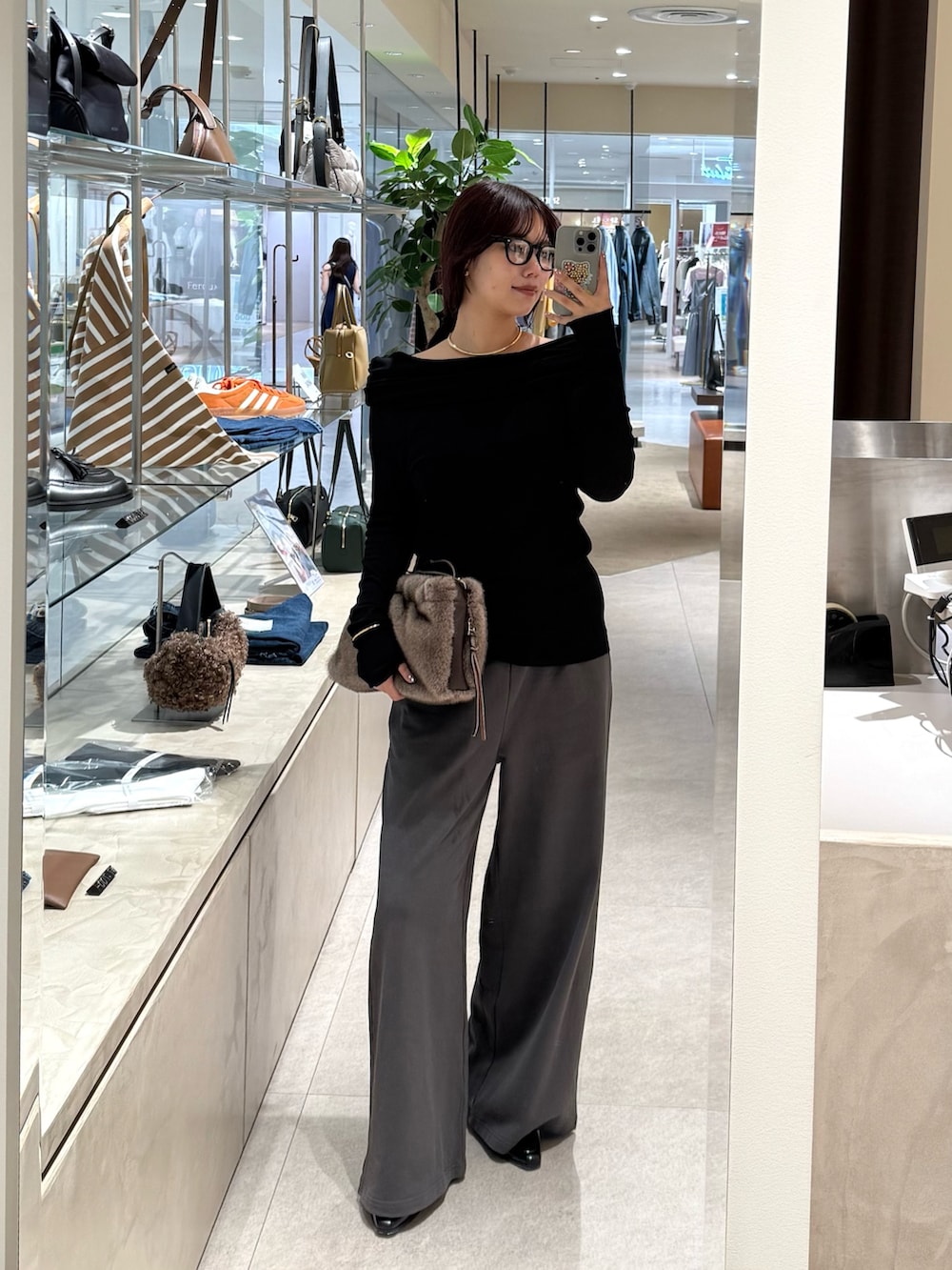 グレー系のその他パンツ、ブラック系のTシャツ/カットソー、ブラウン系のハンドバッグを着用したレディースの秋コーディネートの2枚目の写真